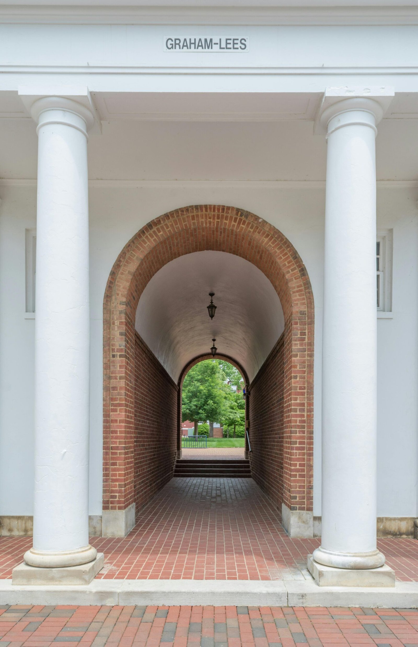 An elegant brick archway with columns leading to a lush garden path, located in Lexington, VA.